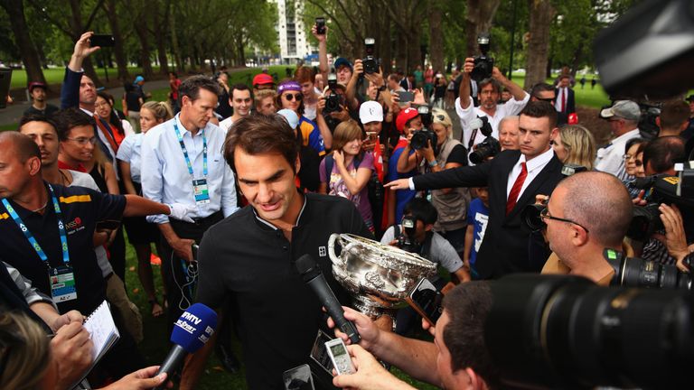 Roger Federer of Switzerland holds the Norman Brookes Challenge Cup as he speaks to the worlds media