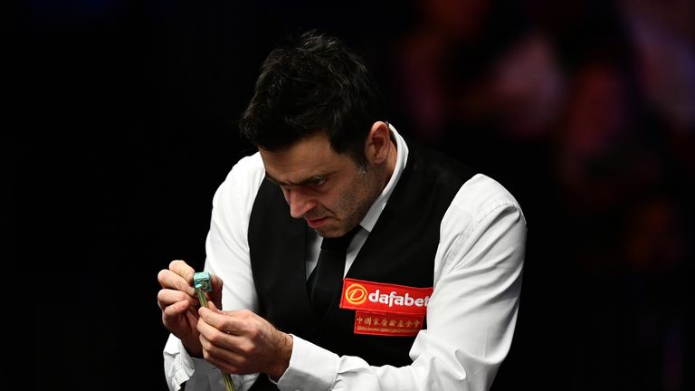 Ronnie O'Sullivan of England takes a look at his cue after changing the tip during his Masters semi final