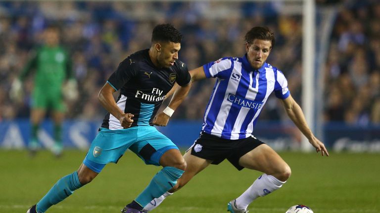 SHEFFIELD, ENGLAND - OCTOBER 27:  Alex Oxlade-Chamberlain of Arsenal and Sam Hutchinson of Sheffield Wednesday compete for the ball during the Capital One 