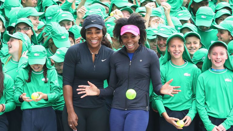 Serena Williams (L) and sister Venus Williams of the USA pose with over 380 Australian Open ballkids