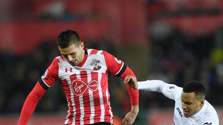 SWANSEA, WALES - JANUARY 31: Dusan Tadic of Southampton and Martin Olsson of Swansea City compete for the ball during the Premier League match between Swan