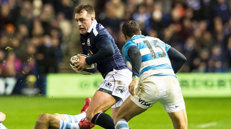 Scotland's Stuart Hogg moves between two Argentina players