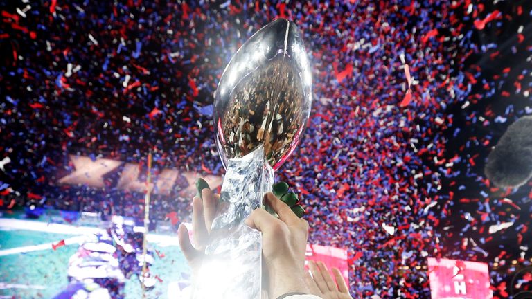 GLENDALE, AZ - FEBRUARY 01:  Members of the New England Patriots celebrate with the Vince Lombardi Trophy after defeating the Seattle Seahawks 28-24 in Sup
