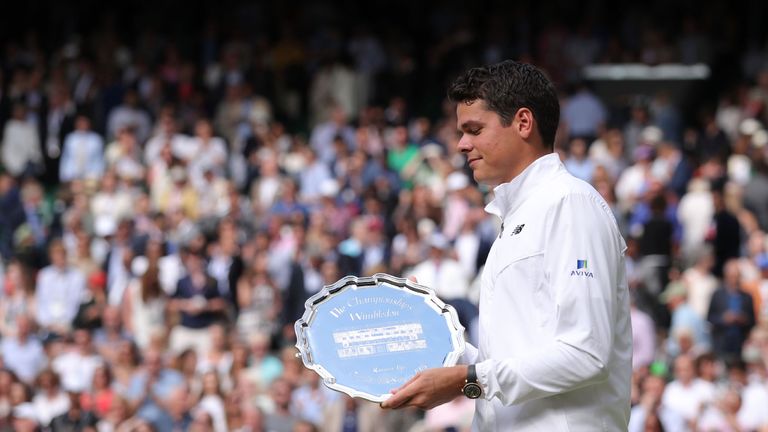 Canada's Milos Raonic poses with the runners up plate after losing the men's singles final to Britain's Andy Murray on the last day of the 2016 Wimbledon C
