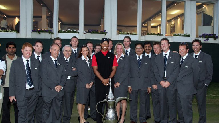 DUBAI, UNITED ARAB EMIRATES - FEBRUARY 03:  Tiger Woods of the USA with the trophy with Emirates Golf Club Staff after winning the Dubai Desert Classic, on