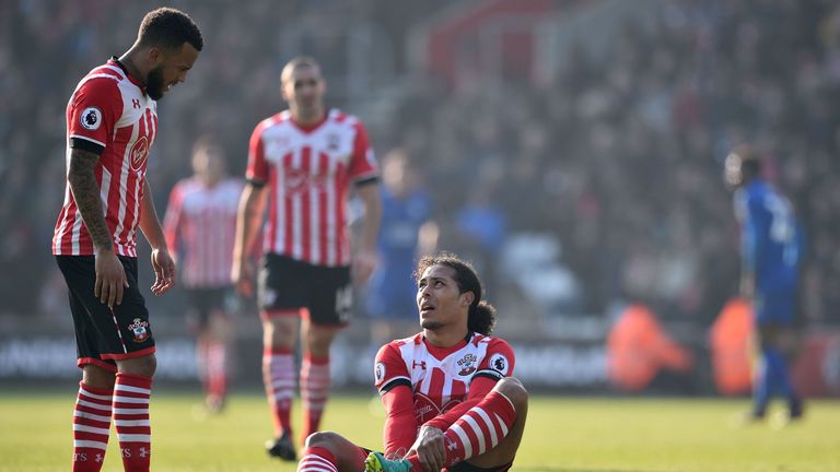 Southampton's Dutch defender Virgil van Dijk (C) sits down injured as Southampton's English defender Ryan Bertrand (L) looks on during the English Premier 