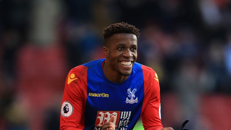 WATFORD, ENGLAND - DECEMBER 26:  Wilfred Zaha of Palace applaudes Watford mascot Harry the Hornet for diving at the final whistle during the Premier League