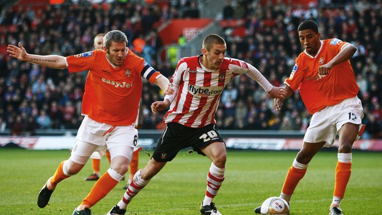 SOUTHAMPTON, ENGLAND - JANUARY 02 2010:  Adam Lallana of Southampton battles for the ball with Kevin Nicholls (L) and Shane Blackett (R) of Luton Town