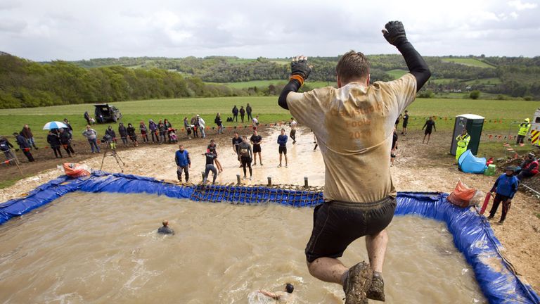 Participant jump from a four meter high platform into water during the Tough Mudder endurance race in Henley on Thames, West of London, on April 26, 2014. 