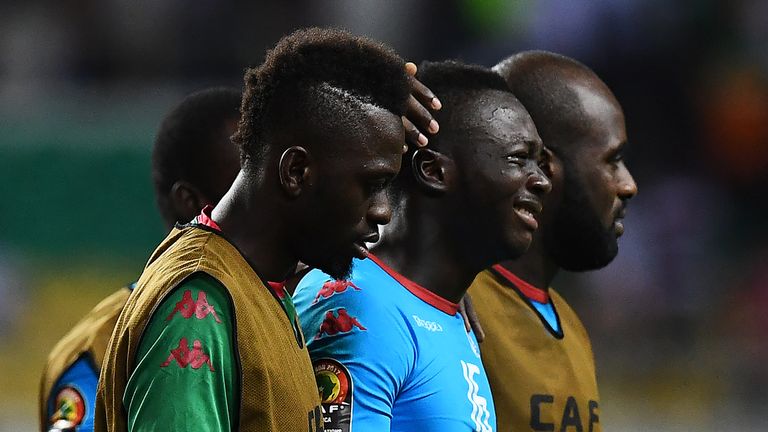 Burkina Faso's goalkeeper Herve Kouakou Koffi (C) is consoled at the end of the penalty shootout
