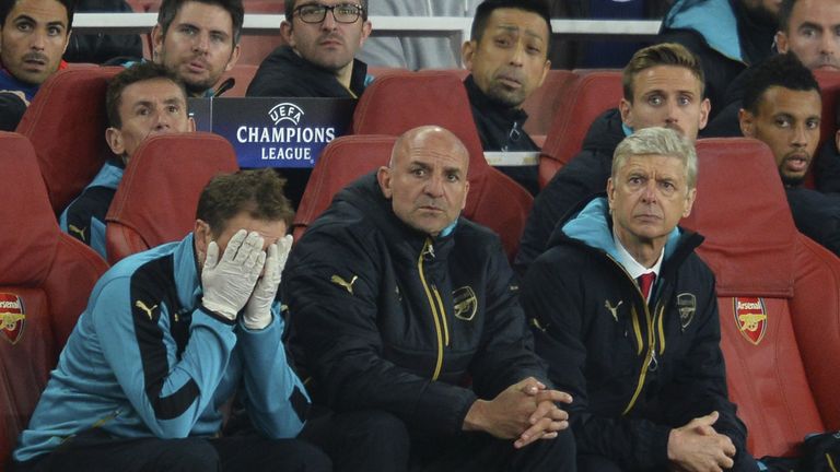 Arsenal's French manager Arsene Wenger (R) and assistant manager Steve Bould (2R) watch the action from the dug out during the UEFA Champions League Group 