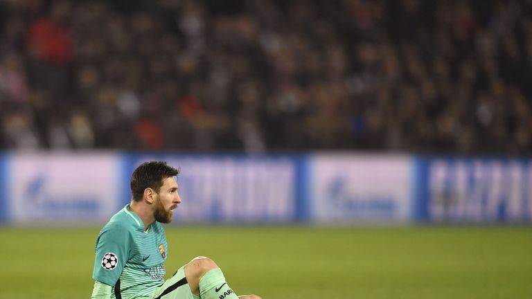 Barcelona's Argentinian forward Lionel Messi sits on the pitch during the UEFA Champions League round of 16 first leg football match between Paris Saint-Ge