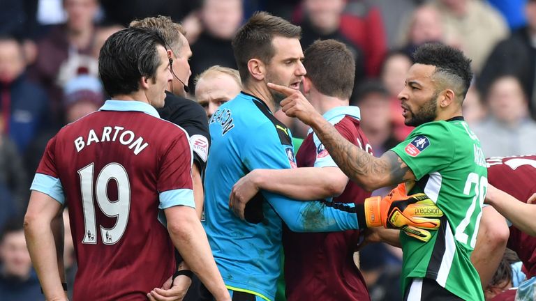 Burnley's English midfielder Joey Barton (L) clashes with Lincoln City's English midfielder Nathan Arnold during the English FA Cup fifth round football ma