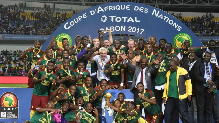 Cameroon team players and Cameroon's Belgian coach Hugo Broos (C) celebrate with the winner's trophy after beating Egypt 2-1 to win the 2017 Africa Cup of 