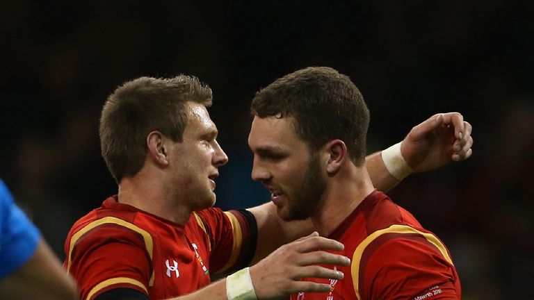 Wales' fly half Dan Biggar (L) congratulates Wales' wing George North on scoring their fifth try during the Six Nations international rugby union match bet