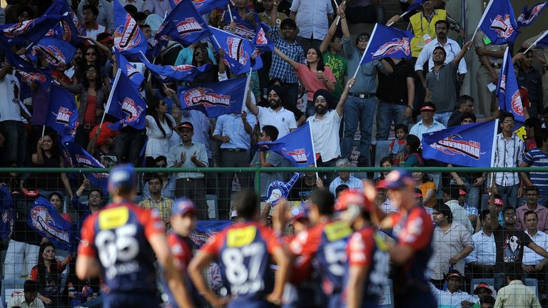 Spectators cheer as Delhi Daredevils cricketers celebrate the wicket of Deccan Chargers batsman J.P. Duminy during the IPL Twenty20 cricket match between D