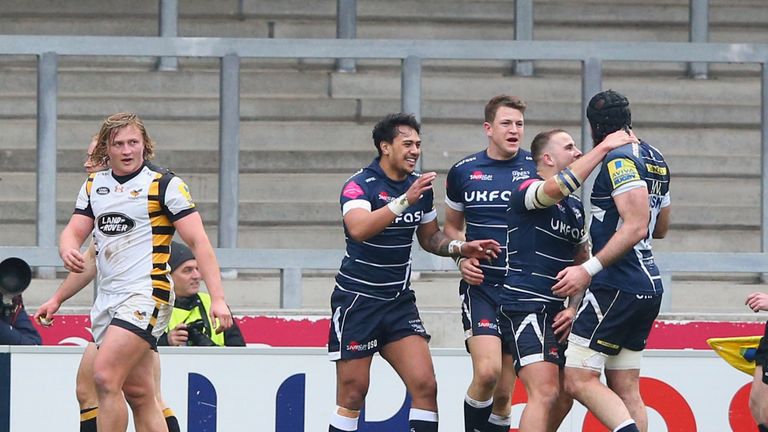 Denny Solomona (middle) celebrates with team-mates after scoring his third try