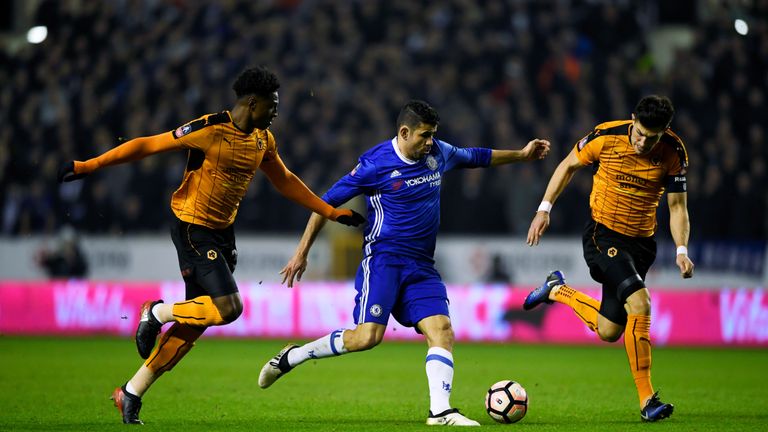 WOLVERHAMPTON, ENGLAND - FEBRUARY 18:  Kortney Hause of Wolves (L) and Danny Batth of Wolves (R) attempt to stop Diego Costa of Chelsea (C) from getting th