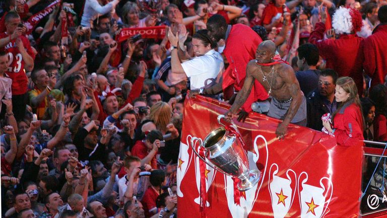 LIVERPOOL, ENGLAND - MAY 26:  Liverpool's French striker Djibril Cisse celebrates with the trophy as the Liverpool team rides on an open top bus through a 