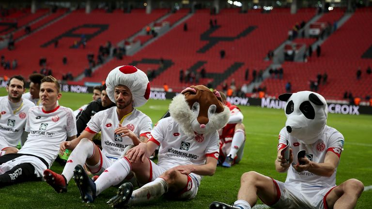 Mainz players celebrate in front of the fans after beating Bayer Leverkusen