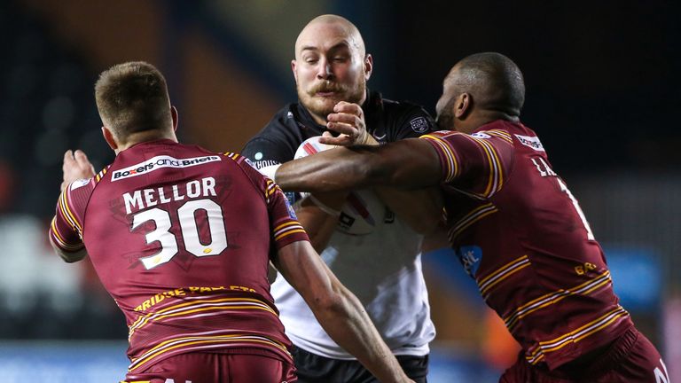  Widnes' Gil Dudson is tackled by Huddersfield's Michael Lawrence and Alexander Mellor.