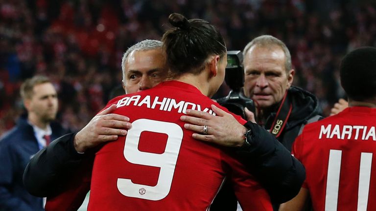 Manchester United's Swedish striker Zlatan Ibrahimovic embraces Manchester United's Portuguese manager Jose Mourinho as players celebrate on the pitch afte