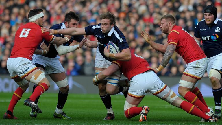 Scotland's lock Jonny Gray (C) is tackled by Wales' lock Jake Ball (centre R) and Wales' flanker Sam Warburton (L) during the Six Nations international rug