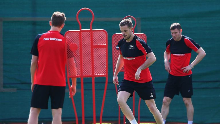 Jordan Henderson runs through a drill while James Milner looks on during a training session at Melwood on May 13, 2016