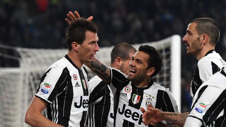 TURIN, ITALY - FEBRUARY 25:  Mario Mandzukic (L) of Juventus FC celebrates after scoring the opening goal with team mates Daniel Alves (C) and Leonardo Bon