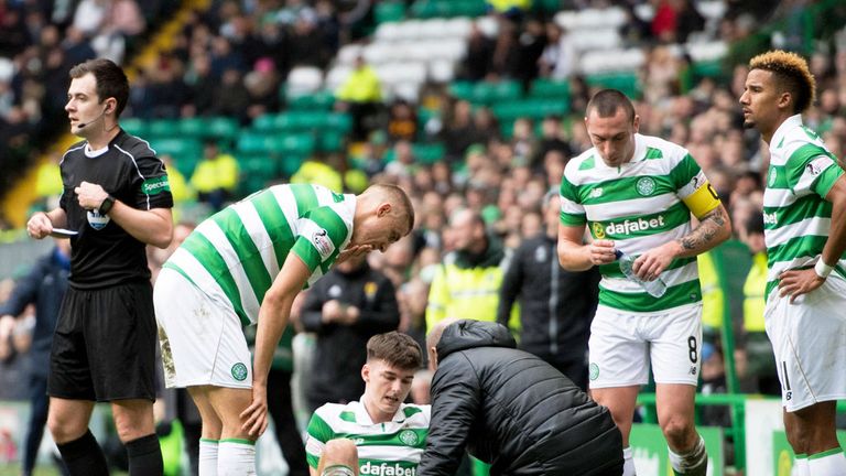 Grounded Celtic defender Kieran Tierney receives treatment for his knee injury