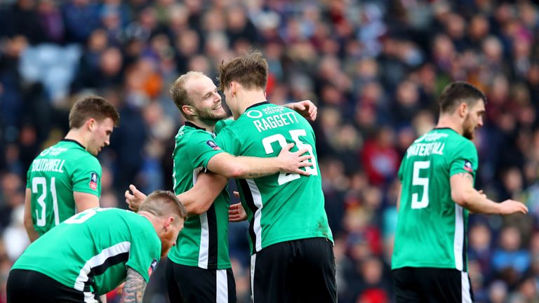 BURNLEY, ENGLAND - FEBRUARY 18: Sean Raggett of Lincoln City (C) celebrates scoring his sides first goal with Bradley Wood of Lincoln City (L) during The E