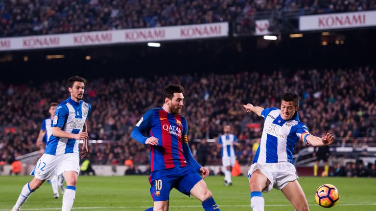 BARCELONA, SPAIN - FEBRUARY 19: Lionel Messi (C) of FC Barcelona shoots on goal between Martin Maximiliano Mantovani (R) and Erik Moran (L) of CD Leganes d