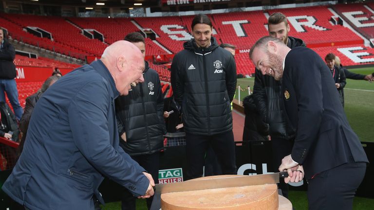 Wayne Rooney and Jean-Claude Biver cut a ceremonial cheese at the launch of a TAG Heuer Special Edition Manchester United Co-Branded Watch at Old Trafford