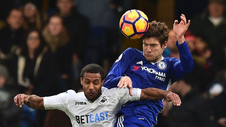 Chelsea's Spanish defender Marcos Alonso (R) beats Swansea City's English midfielder Wayne Routledge (L) in the air during the English Premier League footb