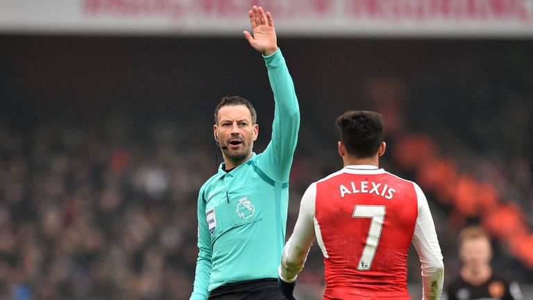 English referee Mark Clattenburg (L) gestures to Arsenal's Chilean striker Alexis Sanchez during the English Premier League football match between Arsenal 