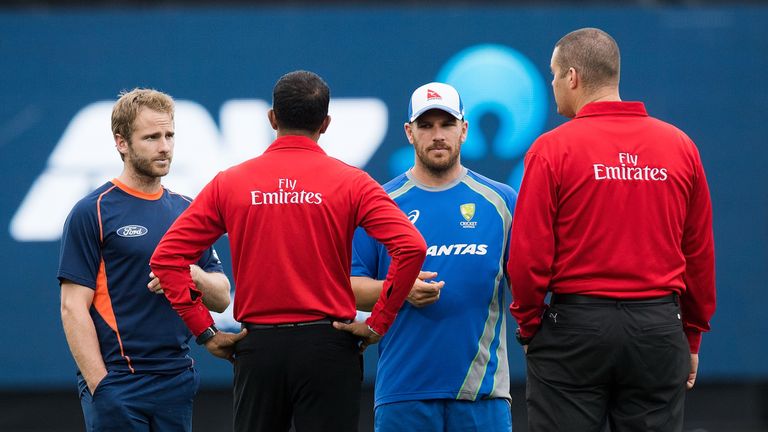 Umpires Kumar Dharmasena (Centre L) and Chris Brown (R) talk to captains Kane Williamson  (L) of New Zealand and Aaron Finch of Australia as rain delays th