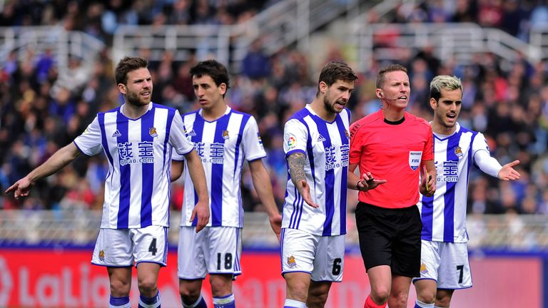 Real Sociedad's defender Inigo Martinez Berridi (C) and Real Sociedad's midfielder Juanmi (R) argue with referee during the Spanish league football match R