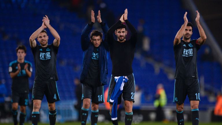 Real Sociedad's midfielder Asier Illarramendi (L), Real Sociedad's defender Raul Rodriguez (C) and Real Sociedad's midfielder Xabi Prieto applaud their fan