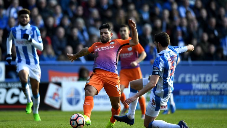 HUDDERSFIELD, ENGLAND - FEBRUARY 18: Sergio Aguero of Manchester City (C) and Mark Hudson of Huddersfield Town (R)