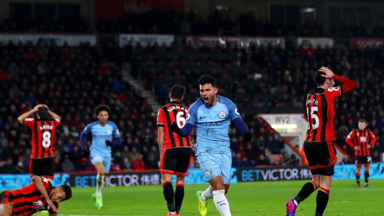 BOURNEMOUTH, ENGLAND - FEBRUARY 13:  Sergio Aguero of Manchester City celebrates after sliding in next to Tyrone Mings of Bournemouth to score his team's s