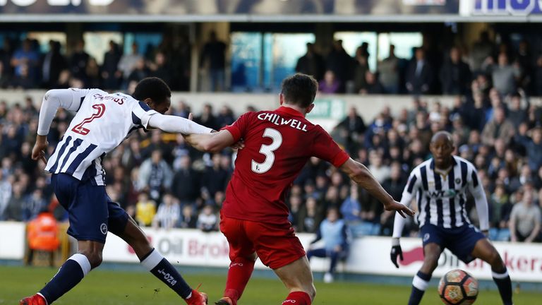 Millwall's English-born Jamaican defender Shaun Cummings (L) shoots to score the opening goal of the English FA Cup fifth round football match between Mill