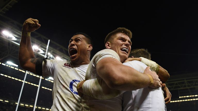 Elliot Daly of England is congratulated by team-mates Nathan Hughes (L) and Owen Farrell