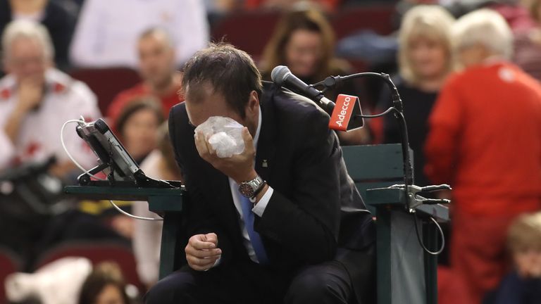 Head referee Arnaud Gabas sits with an ice pack on his eye after Denis Shapovalov of Canada accidently hit him with a tennis ball 