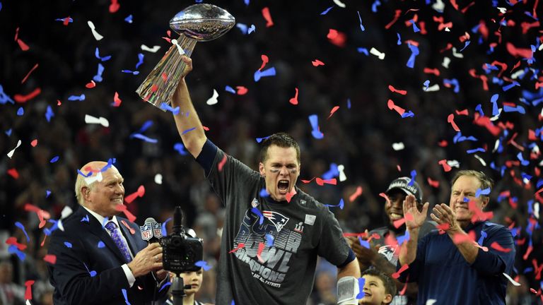 Tom Brady #12 of the New England Patriots holds the Vince Lombardi Trophy as Head coach Bill Belichick (R) looks on  after defeating the Atlanta Falcons 34