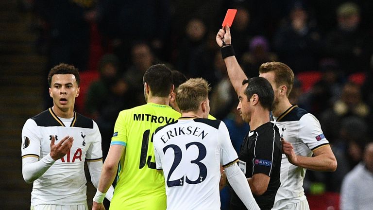 Portuguese referee Jorge Sousa (R) shows a straight red card to send off Tottenham Hotspur's English midfielder Dele Alli (L) during the UEFA Europa League