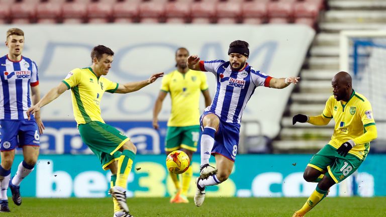 Norwich City's Jonathan Howson (left) and Wigan Athletic's Sam Morsy (centre) battle for the ball during the Sky Bet Championship match at the DW Stadium