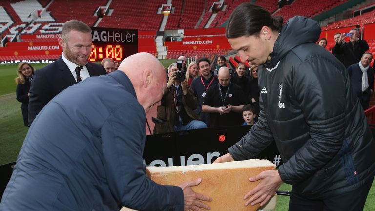 Zlatan Ibrahimovic and Jean-Claude Biver cut a ceremonial cheese at the launch of a TAG Heuer Special Edition Manchester United Co-Branded Watch