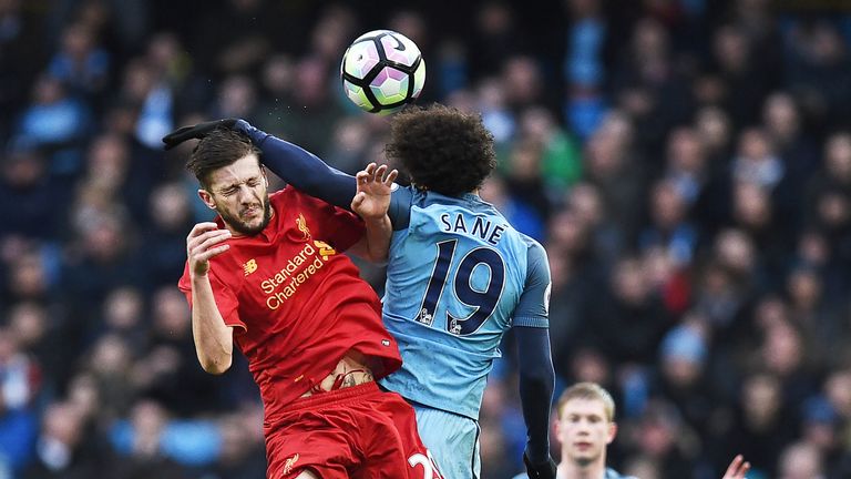 Adam Lallana competes with Leroy Sane for possession of the ball