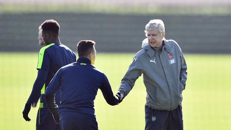 Arsenal's French manager Arsene Wenger (R) shakes hands with Chilean striker Alexis Sanchez (L) during a training session