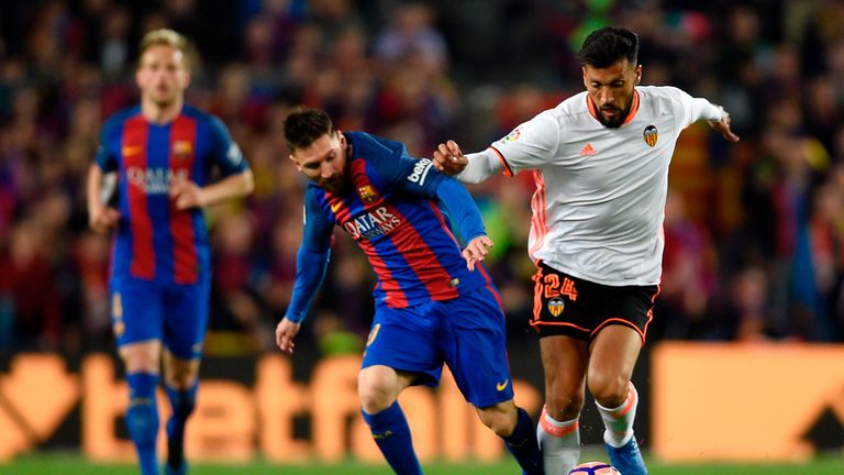 Lionel Messi (L) vies with Ezequiel Garay (R) during the Spanish league football match between Barcelona and Valencia